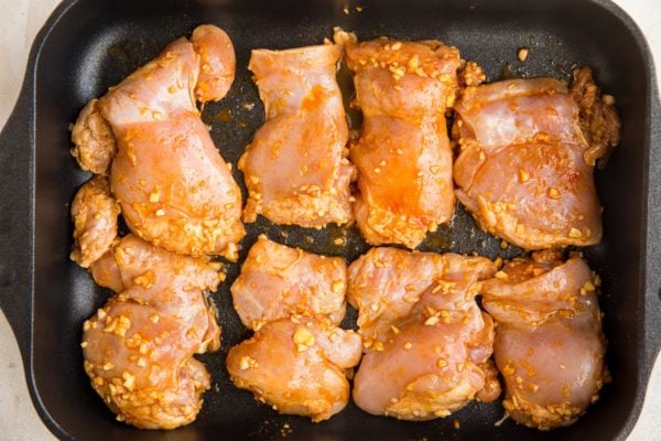 Raw chicken thighs in a casserole dish