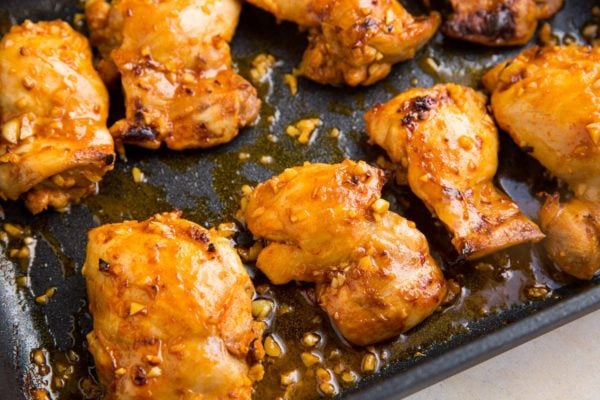 Chicken thighs fresh out of the oven in a baking dish.