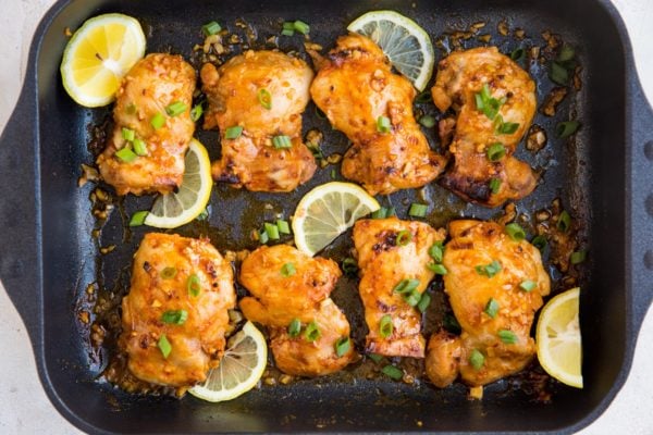 horizontal top down image of a large casserole dish of chicken thighs