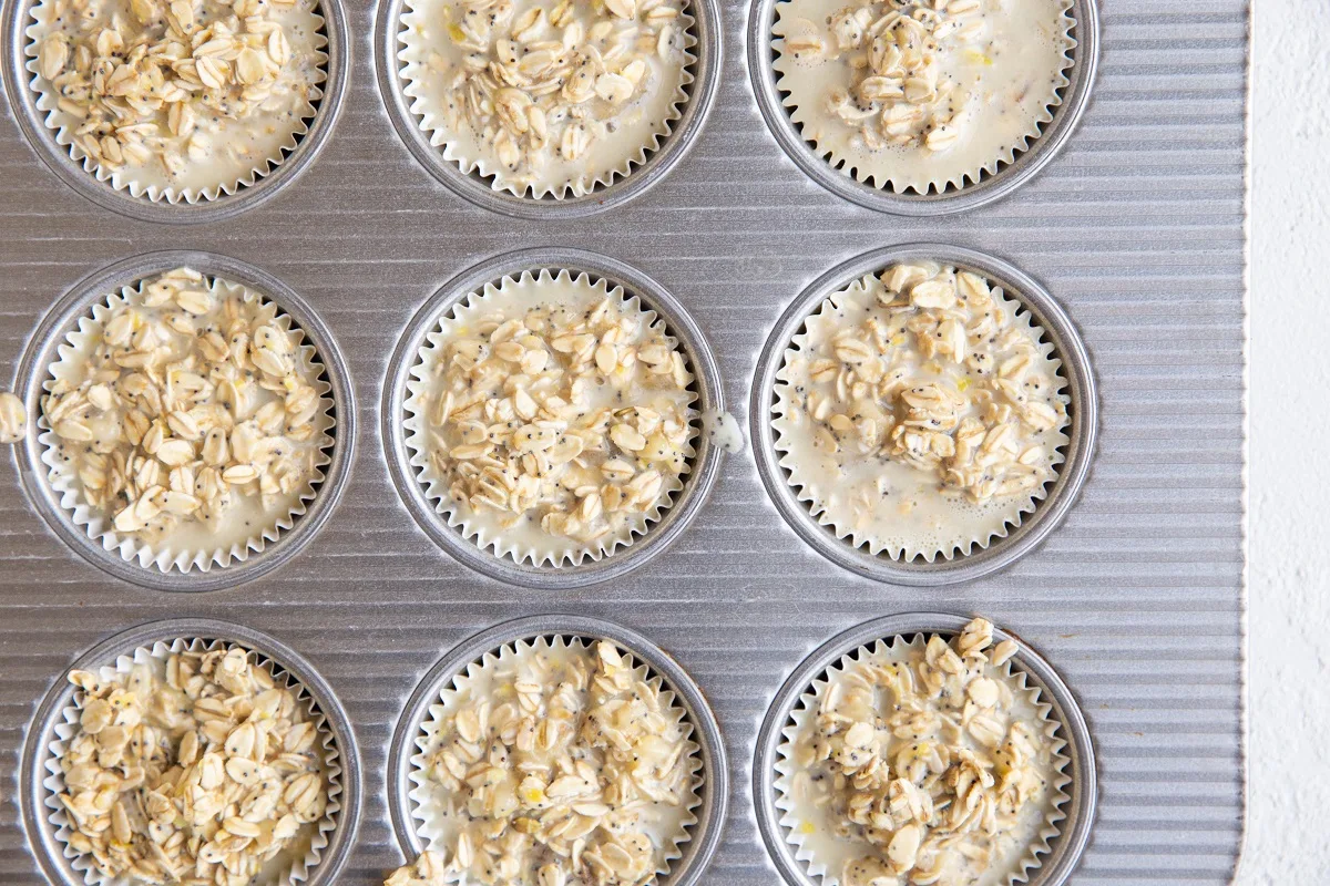 Muffin tray with baked oatmeal batter in muffin papers