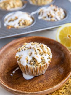 Lemon poppy seed oatmeal muffin on a plate with muffins in the background