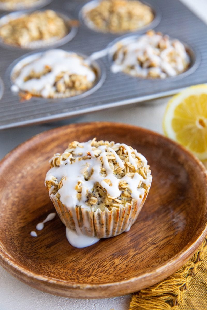 Lemon poppy seed oatmeal muffin on a plate with muffins in the background