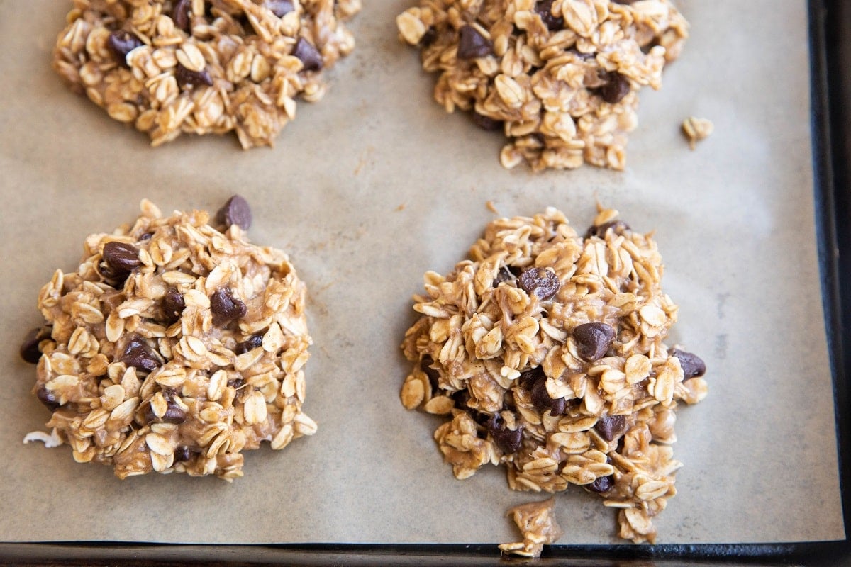 Oatmeal cookie batter sitting on a baking sheet.