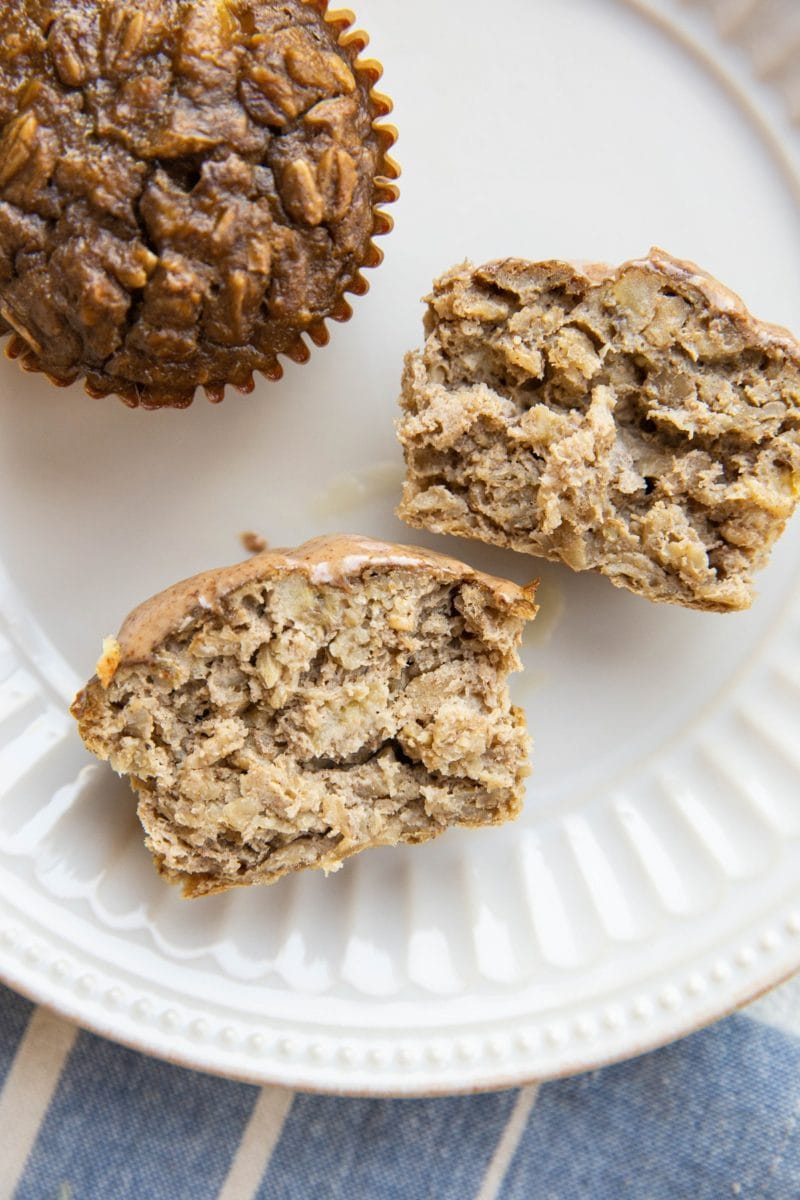 Plate of baked oatmeal muffins with one sliced in half to reveal the inside.