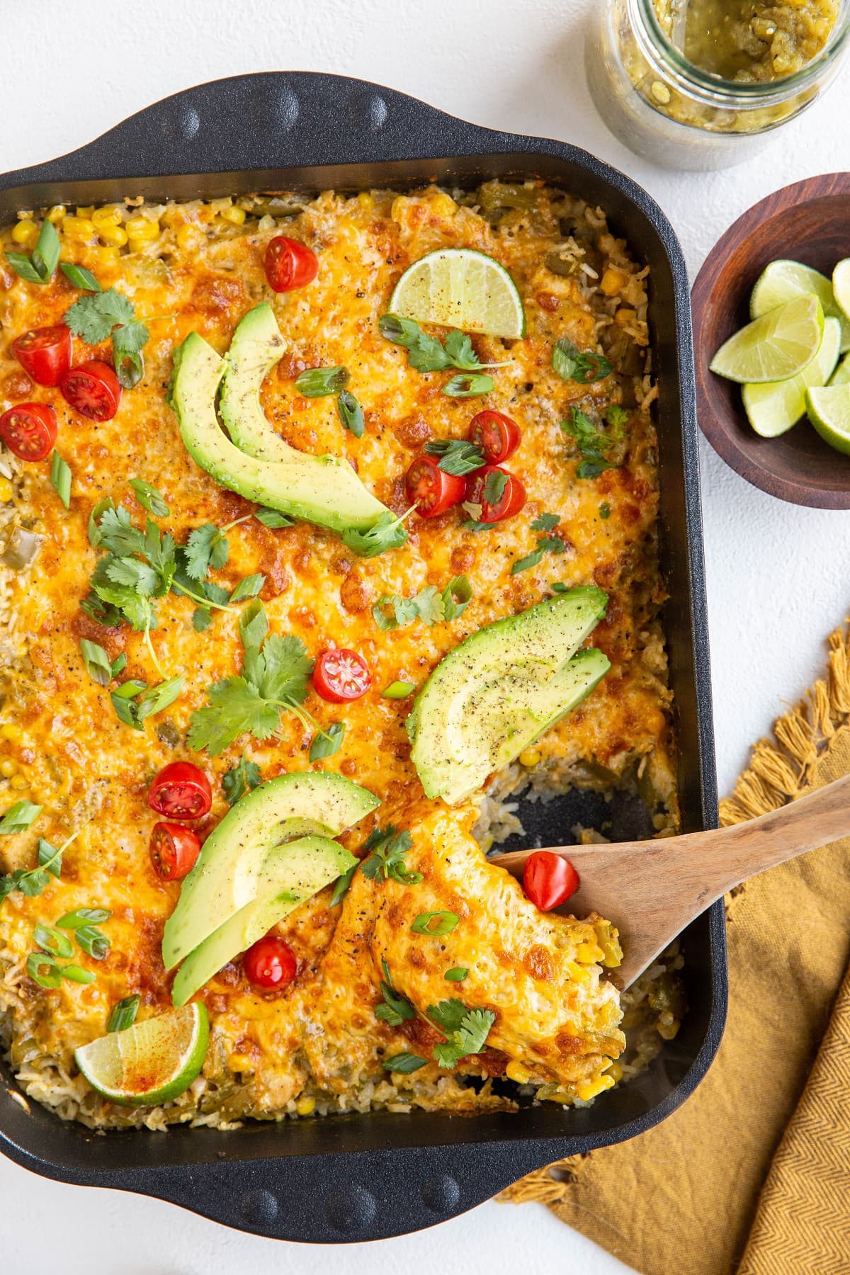 Casserole dish of chicken and rice casserole with a wooden spoon scooping some of it out.