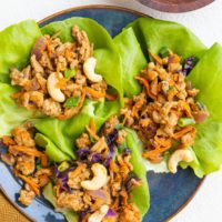 blue plate of Thai ground turkey lettuce wraps with golden napkin to the side.