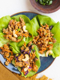 blue plate of Thai ground turkey lettuce wraps with golden napkin to the side.