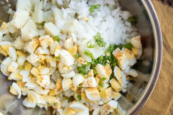 Ingredients for potato salad in a mixing bowl.