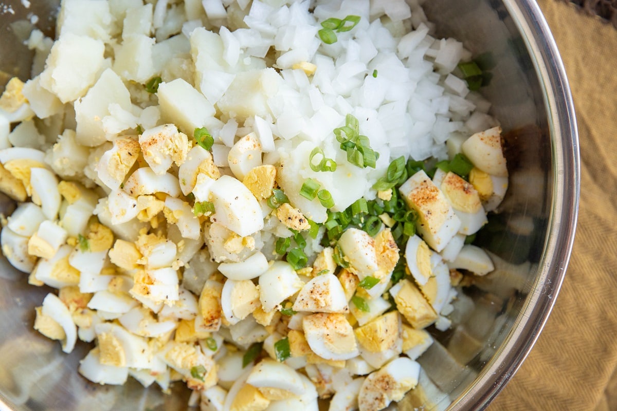 Ingredients for potato salad in a mixing bowl.