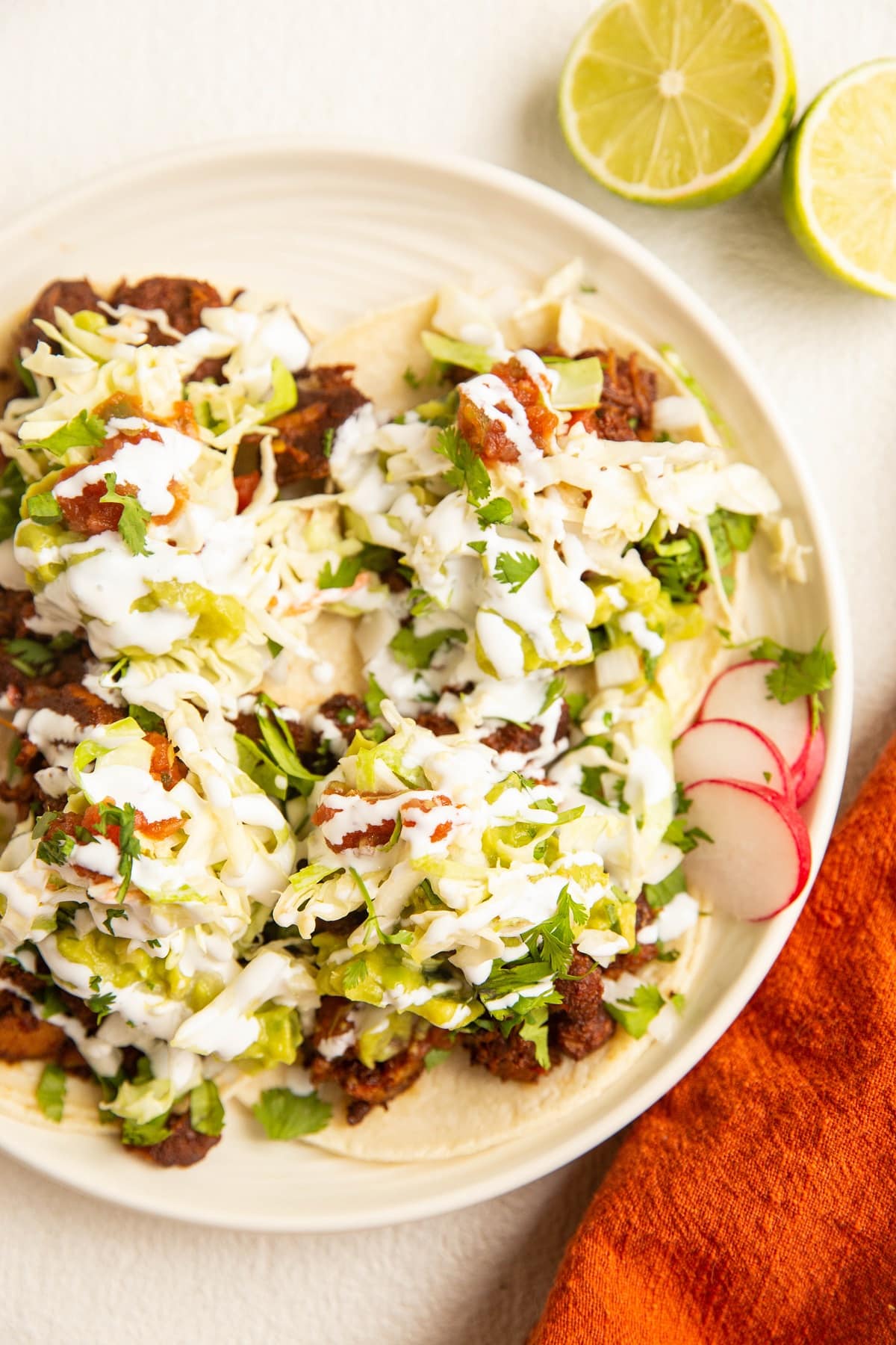 top down photo of plate of al pastor tacos with toppings