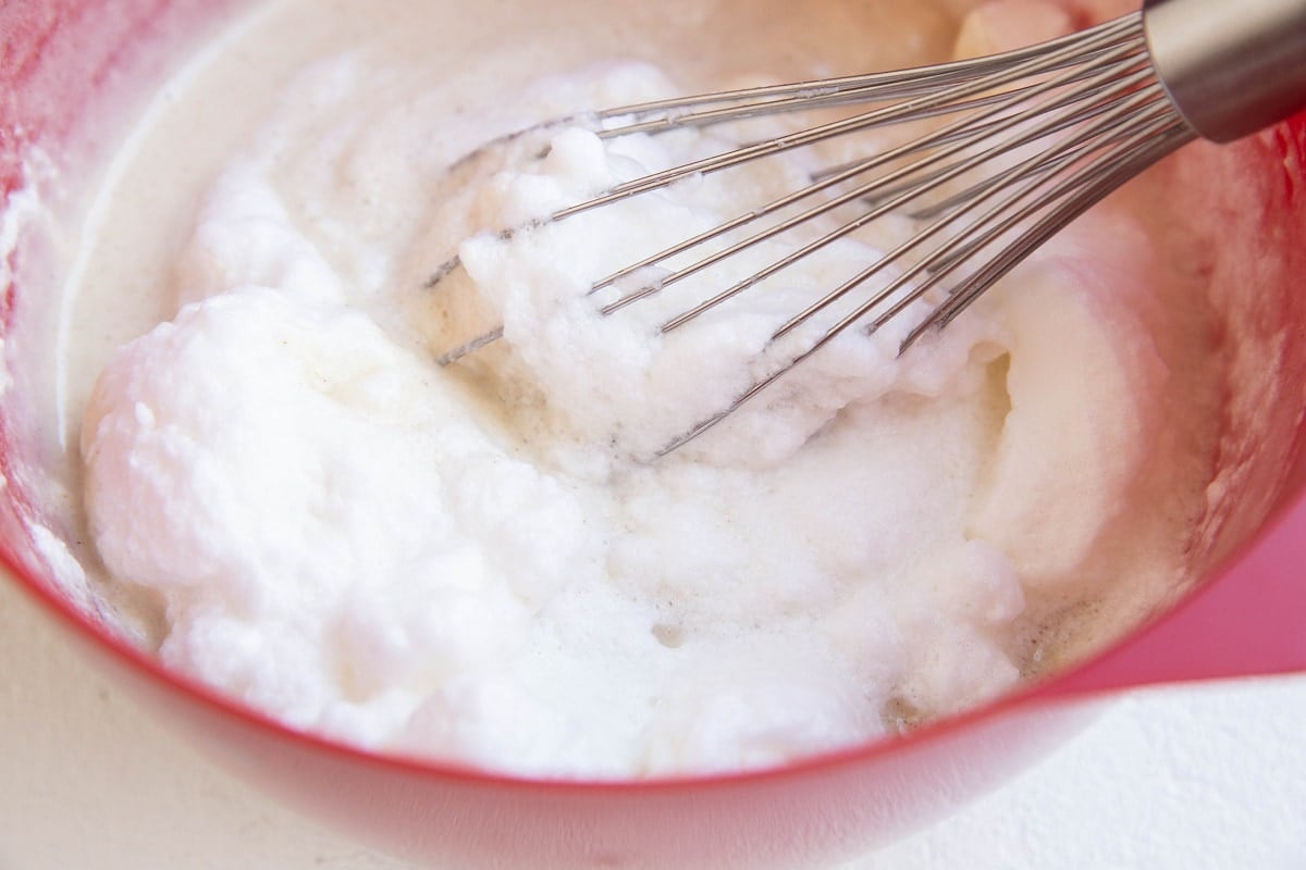 Mixing bowl with waffle batter and fluffy egg whites