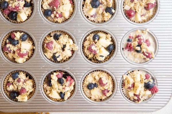 Muffin tin with oatmeal mixture in the holes, ready to go into the oven.