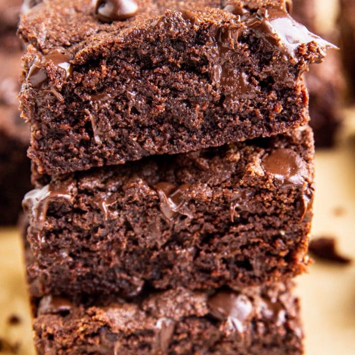 Stack of three brownies close up on parchment paper.