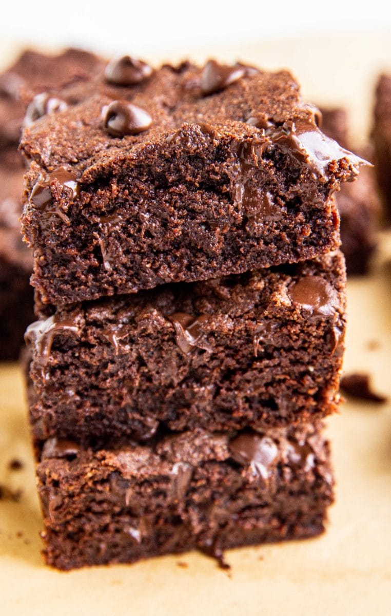 Stack of three brownies close up on parchment paper.
