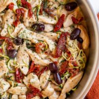 top down stainless steel skillet of zoodles and chicken