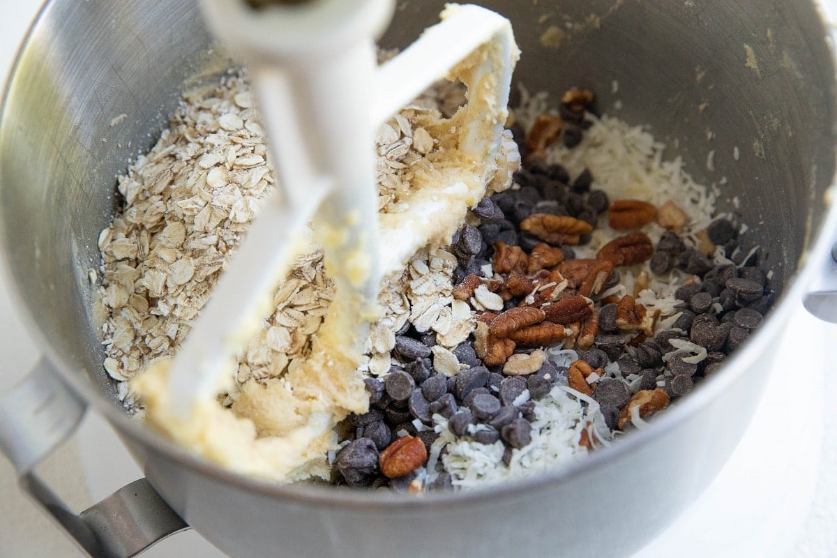 Oats, pecans, shredded coconut, and chocolate chips in a stand mixer