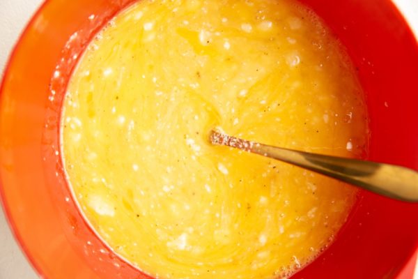 Eggs and feta whisked in a mixing bowl