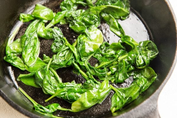 Spinach sauteed in a cast iron skillet