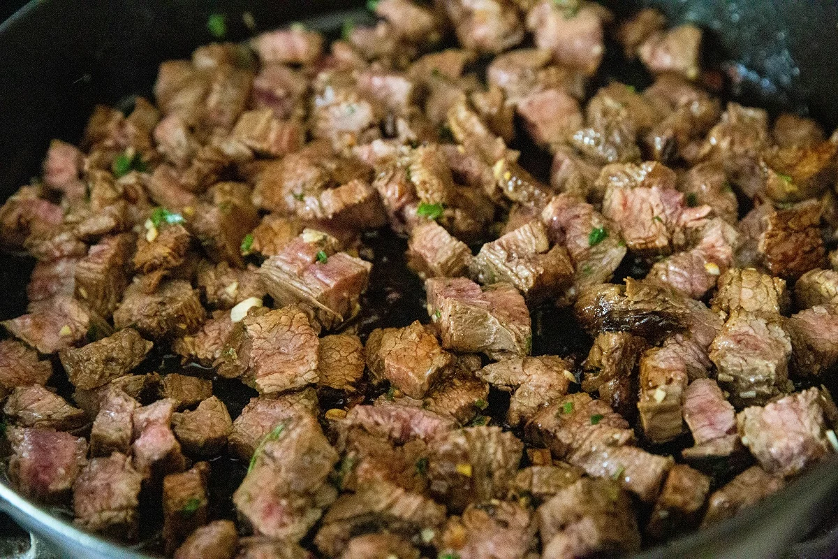 chunks of carne asada in a cast iron skillet