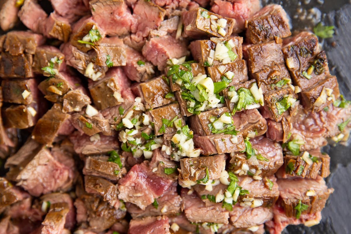 chopped carne asada on a cutting board.