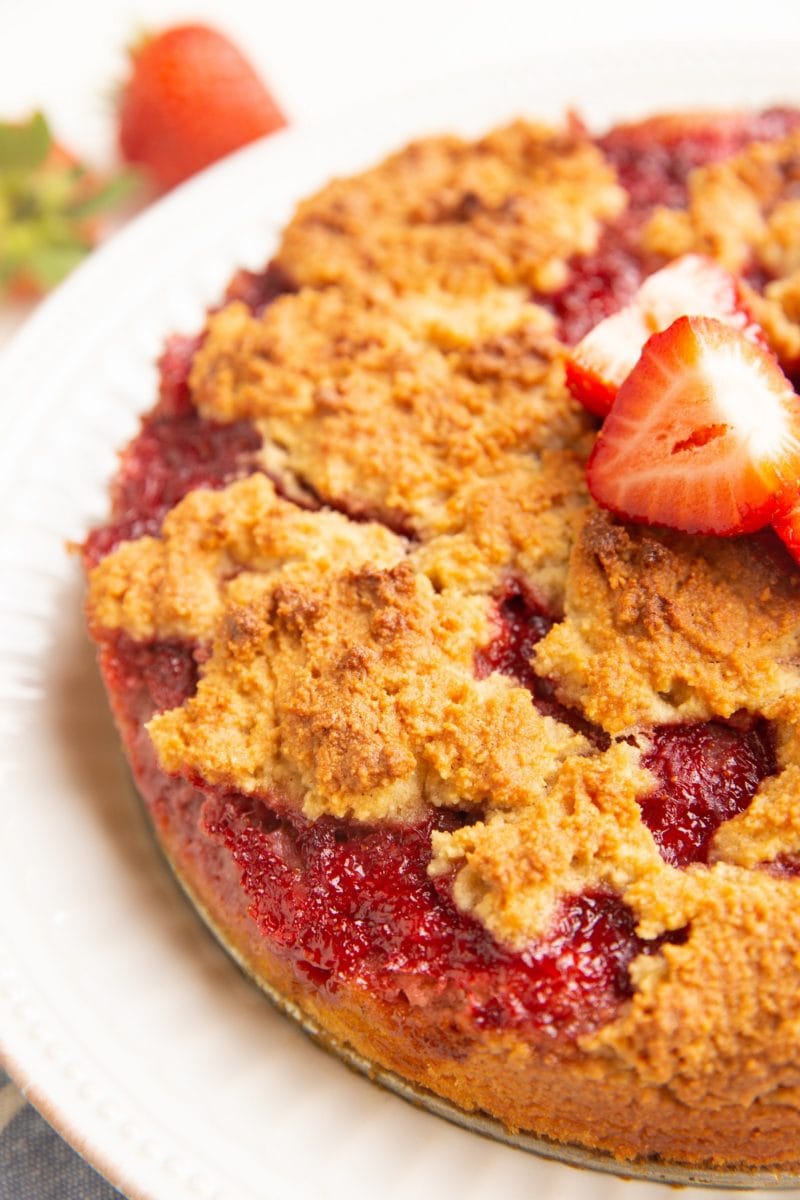 close up of strawberry crumb cake on a white plate