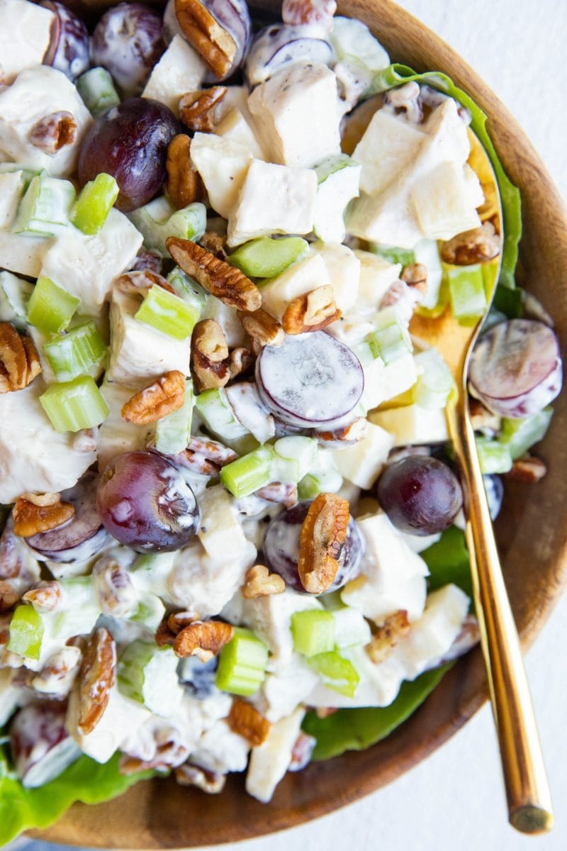 close up top down photo of chicken salad with pecans, grapes, celery, and apples in a bowl.