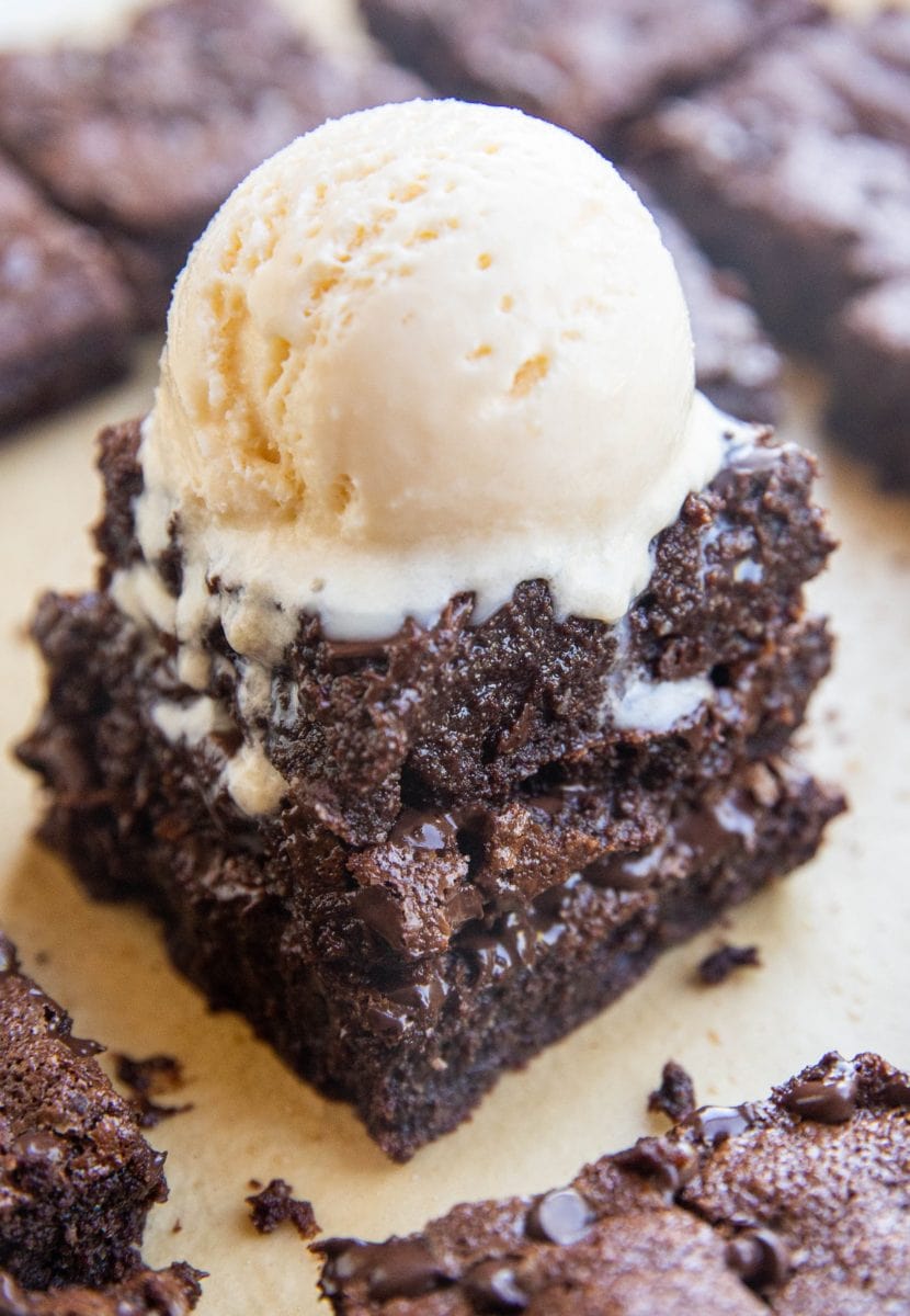 Three brownies stacked on top of each other with a scoop of vanilla ice cream on top