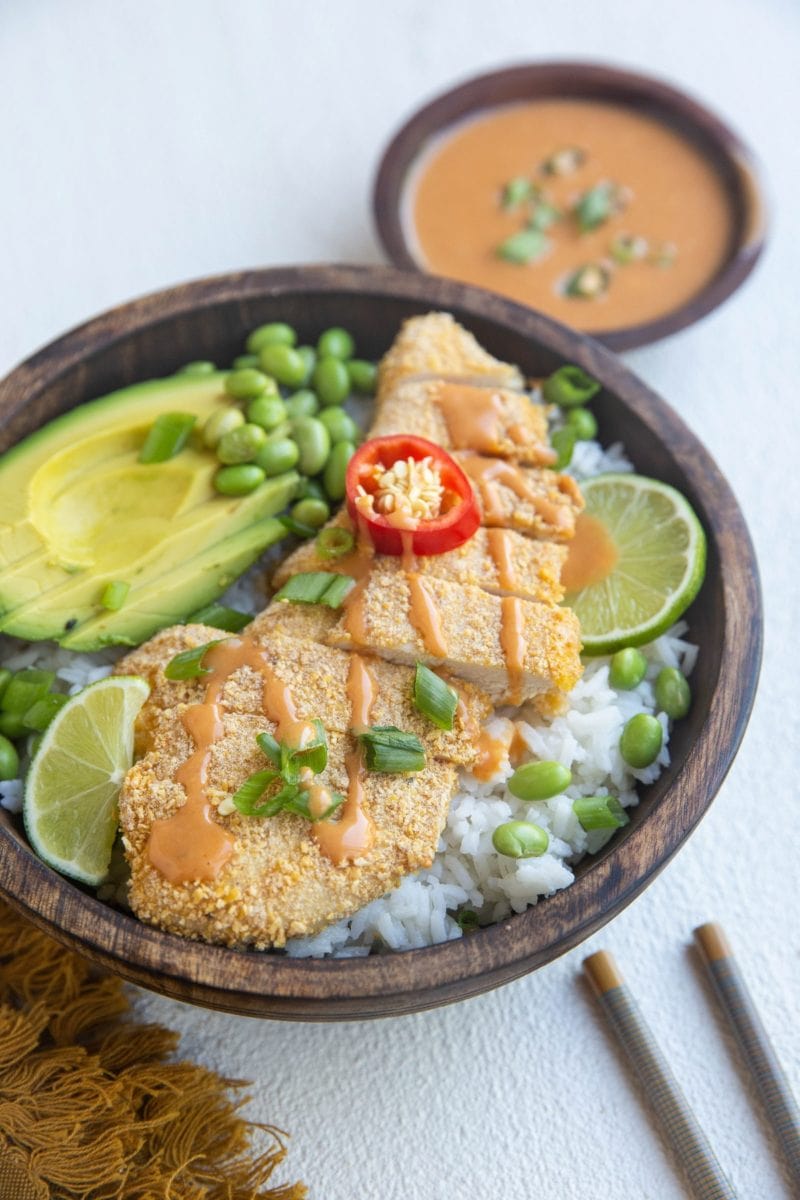 beautiful rice bowl with crispy japanese chicken, avocado and sauce
