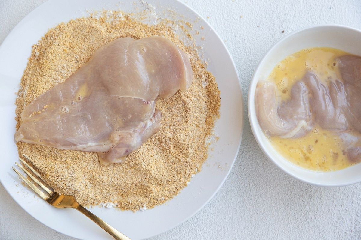 Chicken dredged in egg mixture and in breadcrumbs