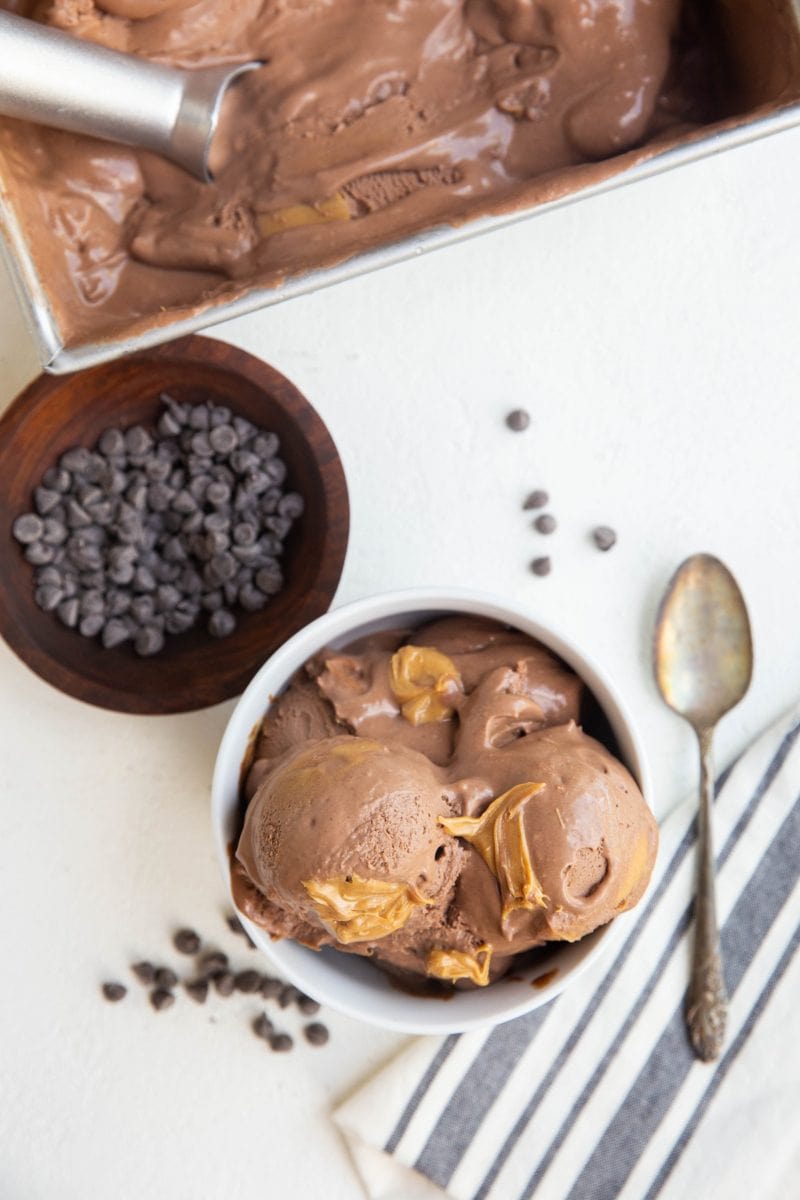 top down photo of chocolate peanut butter ice cream in a bowl with chocolate chips and a napkin off to the side.