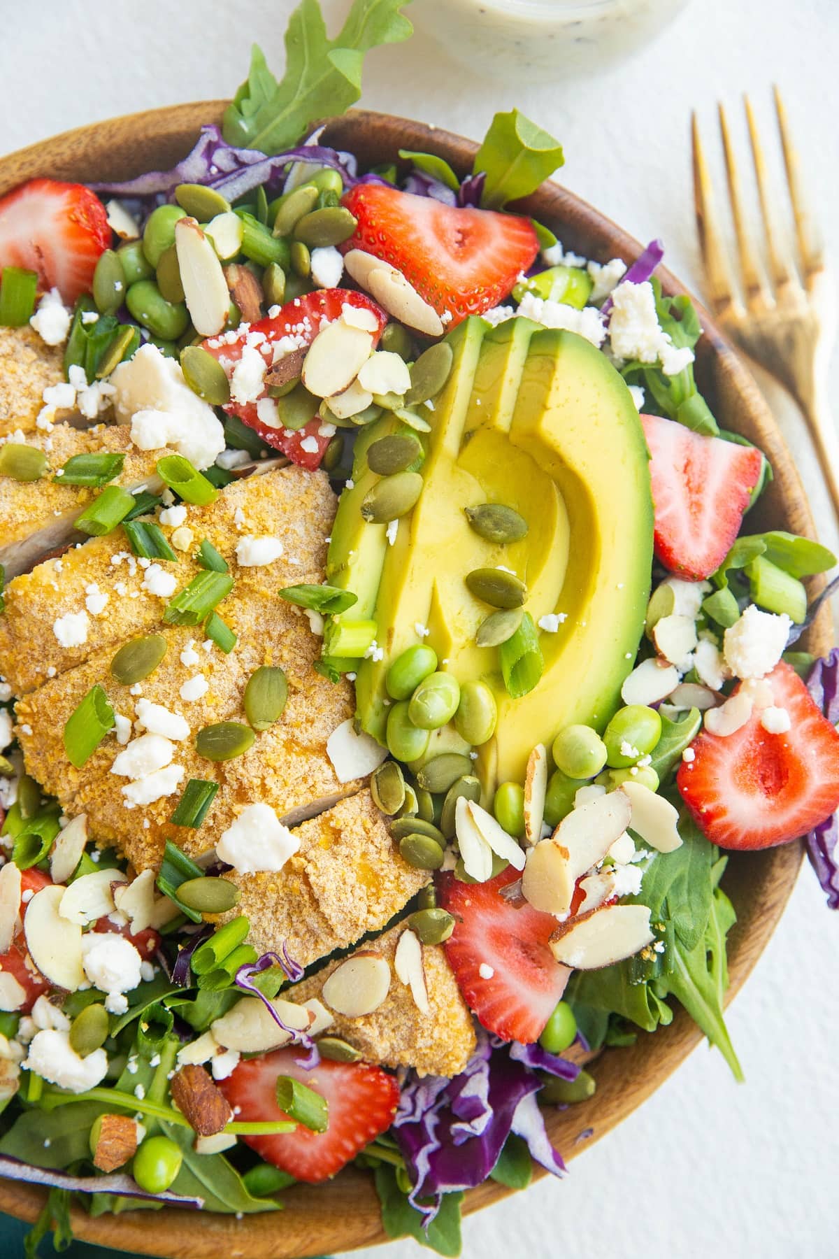 Wooden bowl of chicken salad with avocado