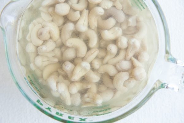 cashews soaking in a measuring cup