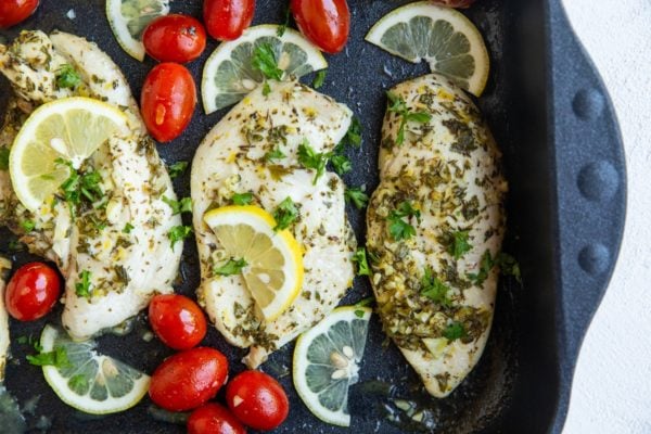 Greek chicken fresh out of the oven in a roasting pan