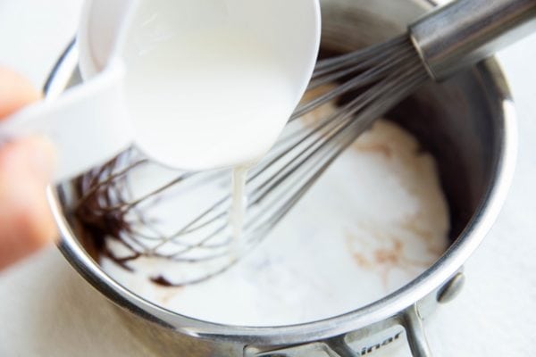 Pouring heavy cream into the pan with the cocoa