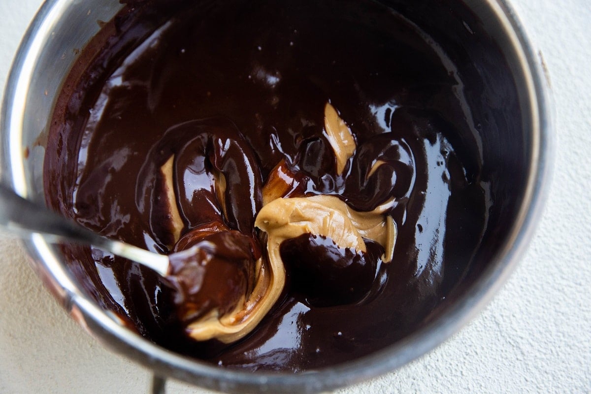 Chocolate ganache with peanut butter being stirred in.
