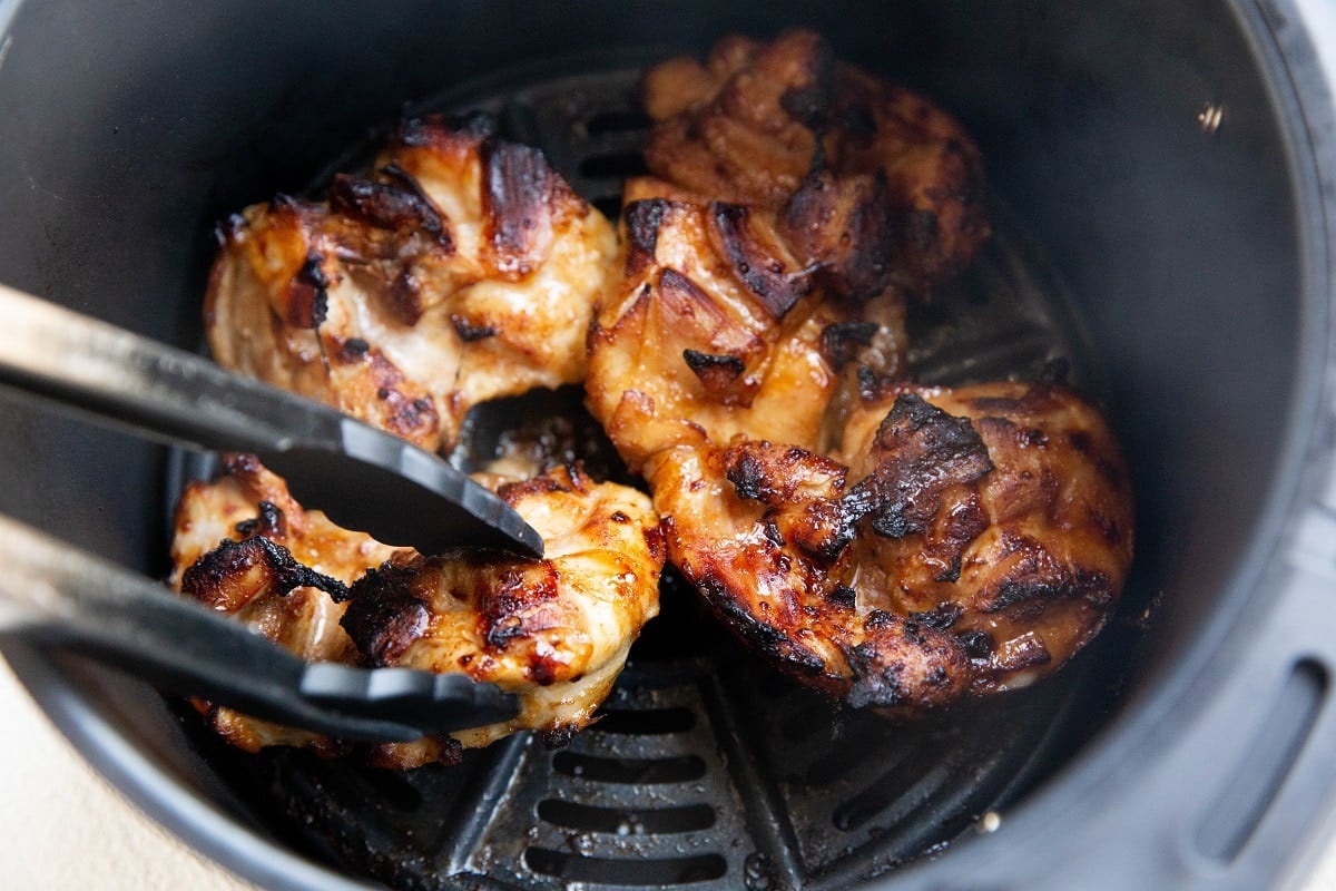 Flipping the chicken part-way through cooking.