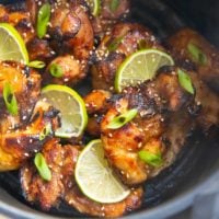 Finished asian chicken in the basket of an air fryer.