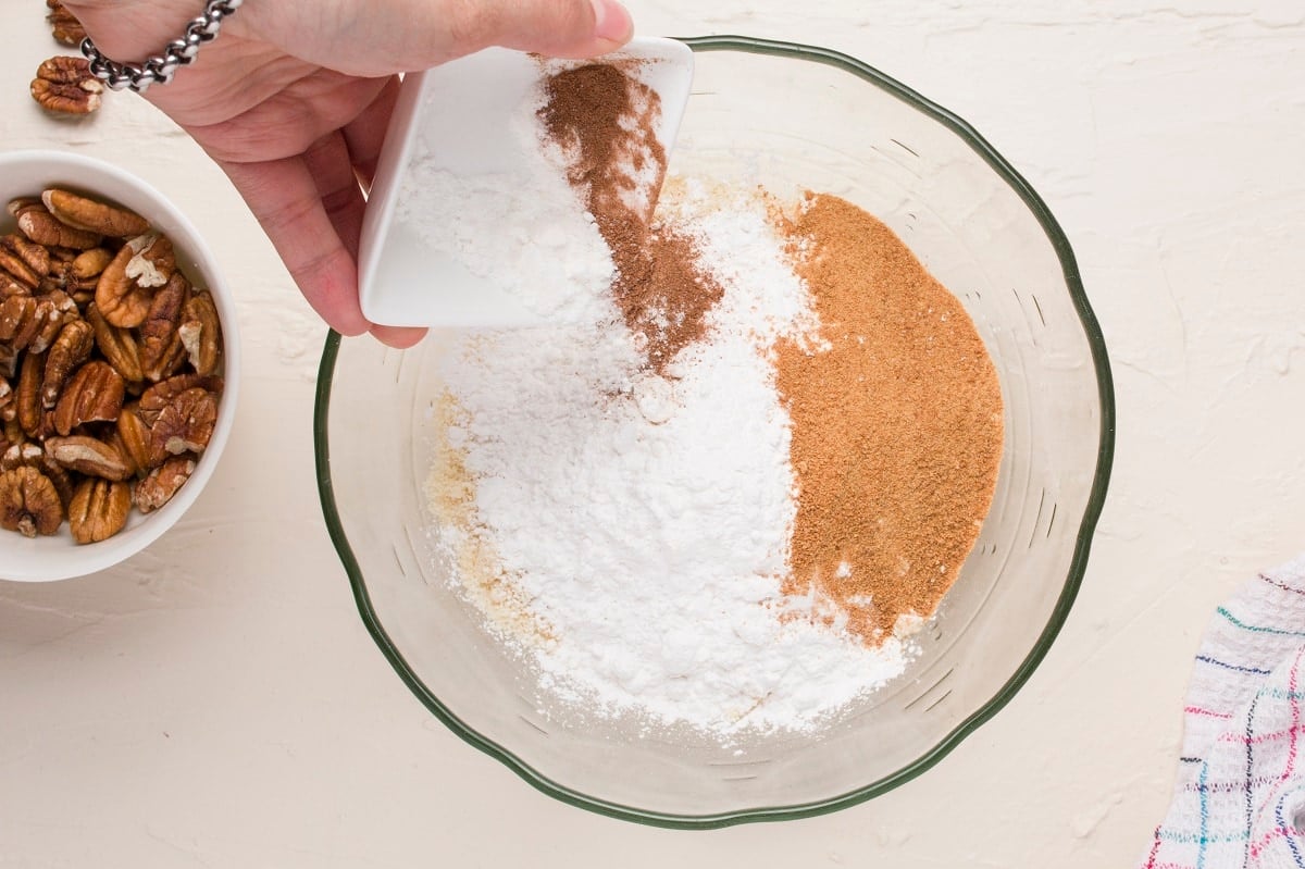Pouring dry ingredients into a bowl to make coffee cake.