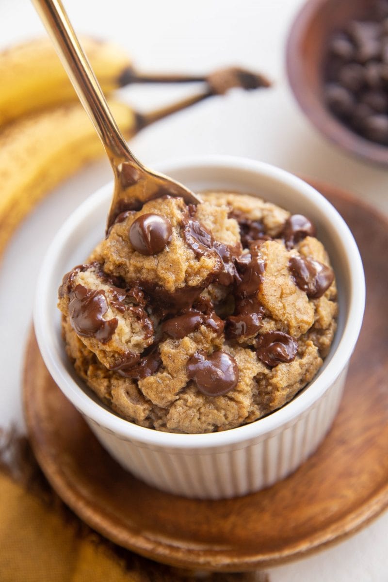 Spoon digging out banana baked oats from a ramekin.