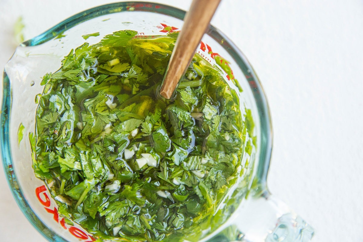 Chimichurri sauce in a measuring cup.