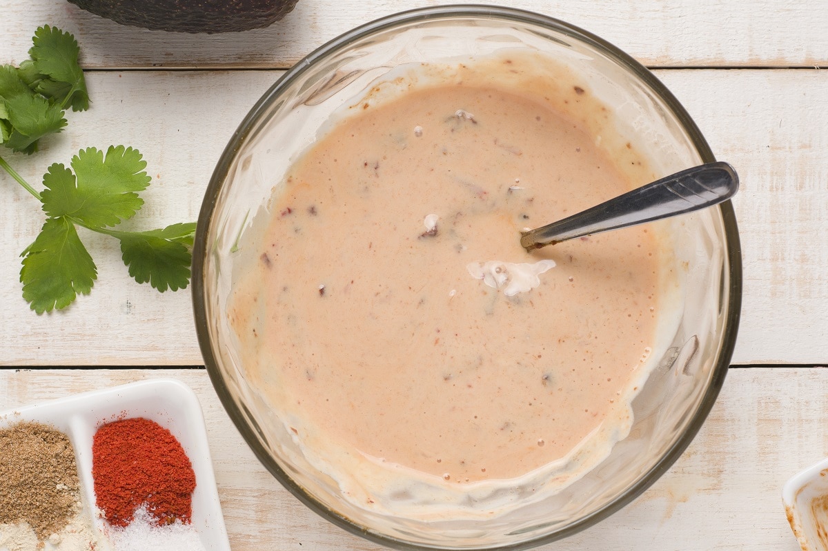 Finished chipotle lime sauce in a bowl on a white backdrop.