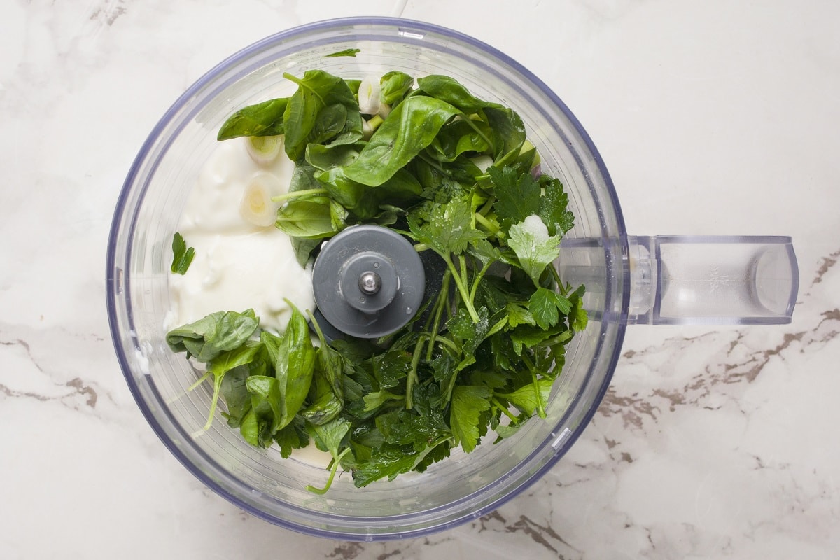 Ingredients for goddess dressing in a food processor, ready to be blended.