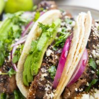 Flank steak tacos on a plate.