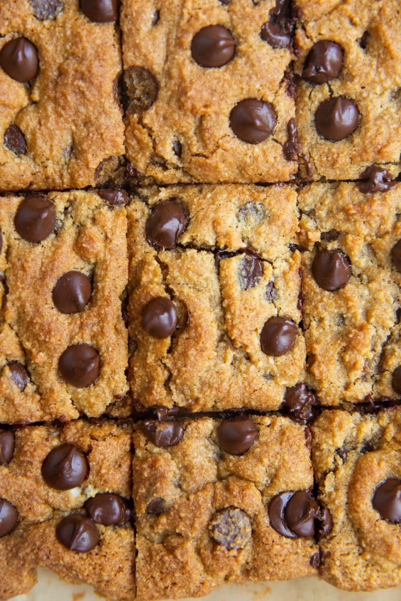 Sliced pumpkin blondies on a sheet of parchment paper.