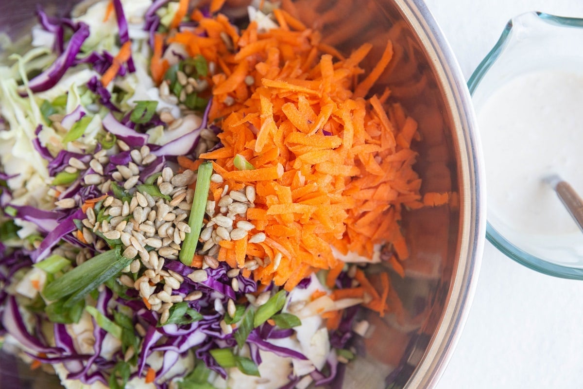 Stainless steel bowl of shredded veggies for slaw