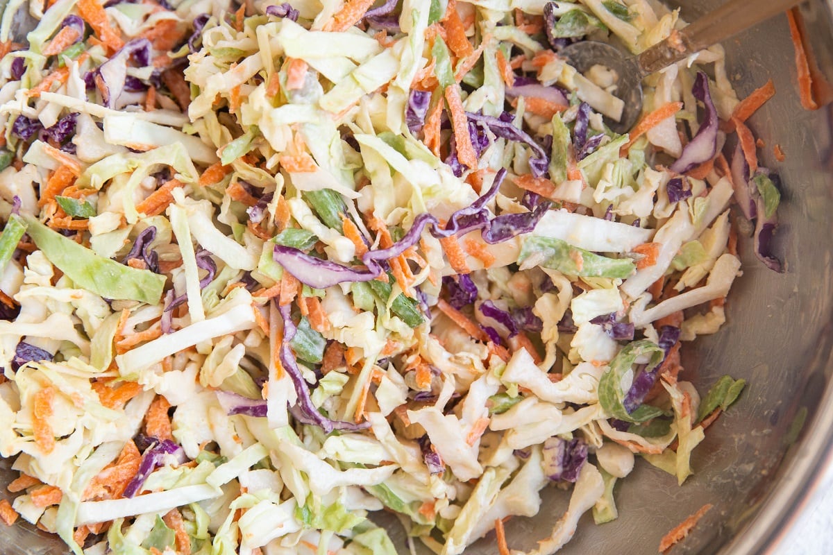 Coleslaw ingredients all mixed together in a mixing bowl.