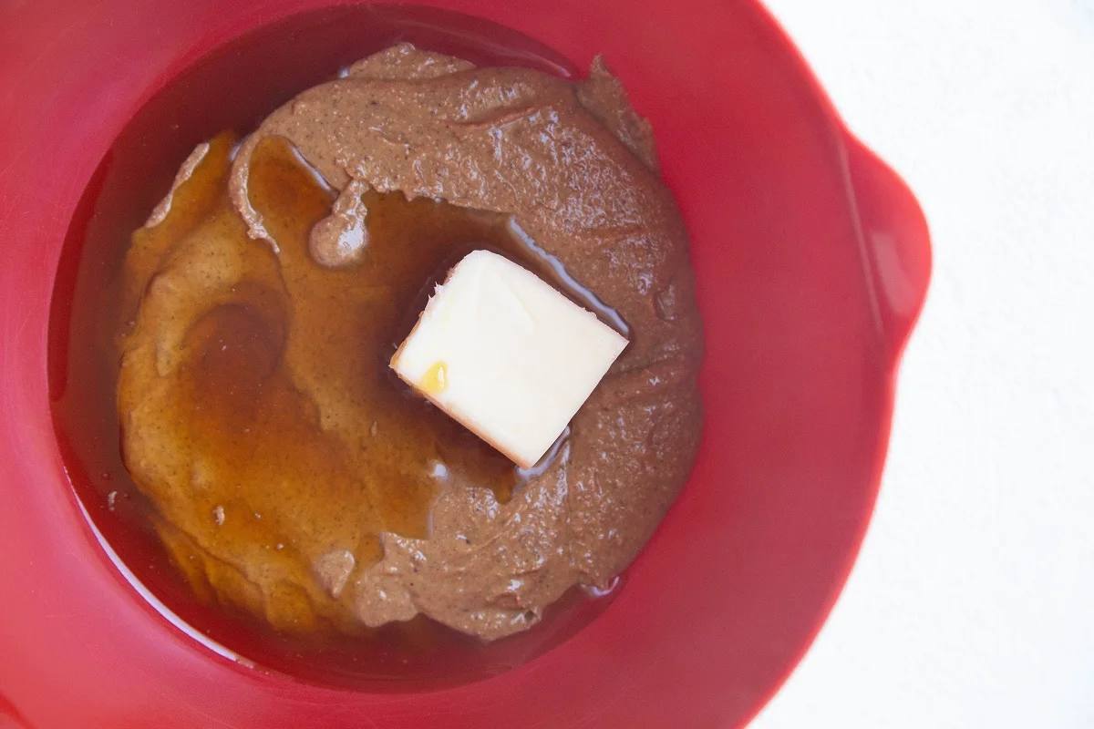 Wet ingredients for almond butter rice crispy treats in a mixing bowl.