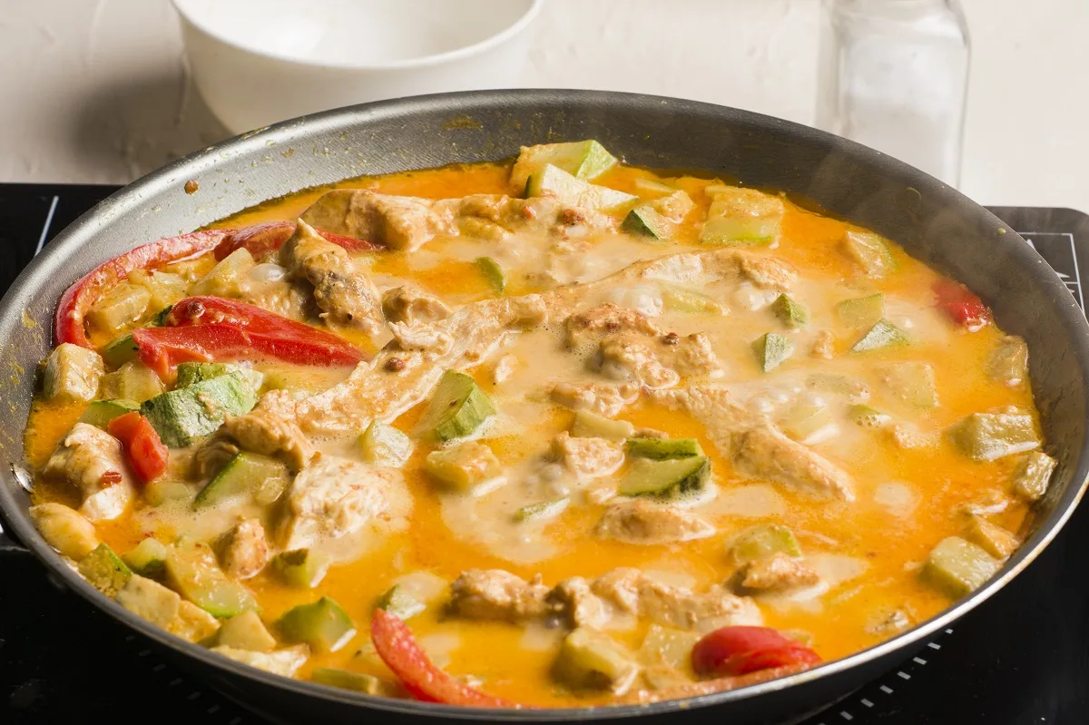 Finished Red Thai Curry Chicken in a skillet on the stove top