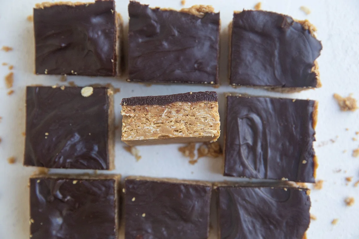 horizontal photo of peanut butter oatmeal bars with one tipped up so you can see the layers