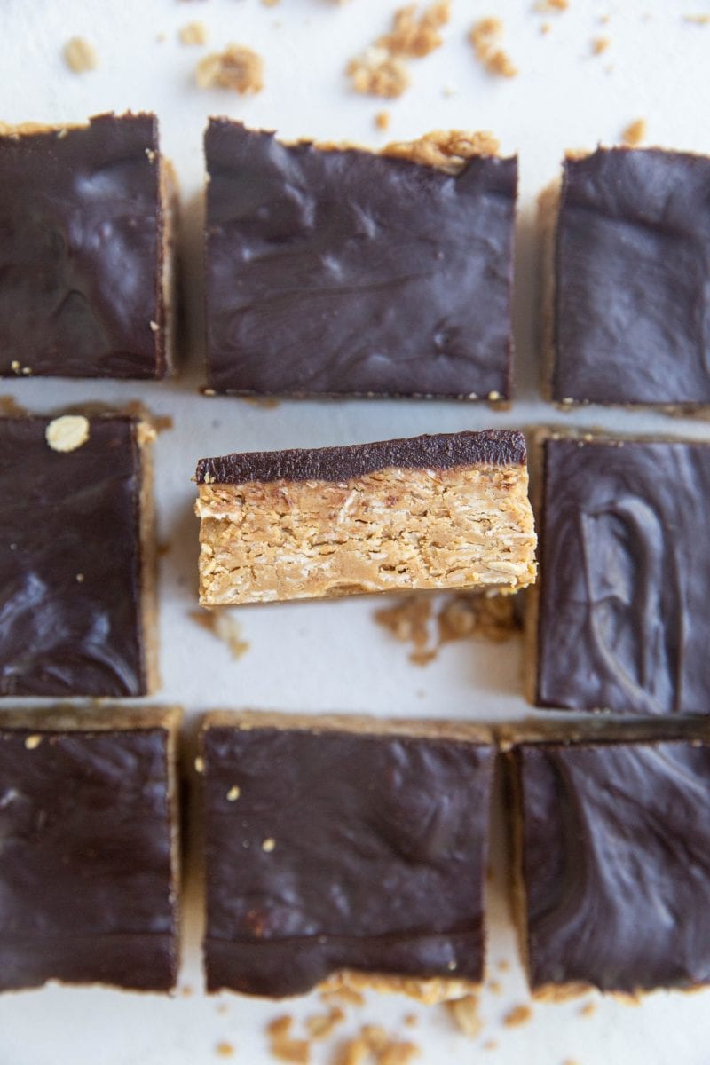 Top down photo of peanut butter chocolate bars with one bar tipped up so you can see the layers.